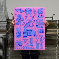 a person holding up a pink poster with blue images on it