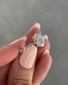 a woman's hand holding an engagement ring with two diamonds on it and a diamond band