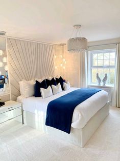 a white and blue bedroom with a large bed