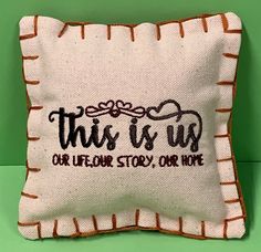 this is us embroidered pillow on a green background with the words, our heart story our hope