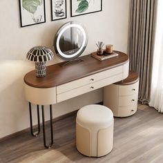 a dressing table with mirror, stool and pictures on the wall