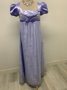 Beautiful lavender satin and embroidered organza dress perfect for those tea parties or regency gatherings.. Please note it takes me 5-8 business days to produce and ship your dress after order is placed . THERE IS NO RETURNS OR EXCHANGES ACCEPTED  PLEASE BE SURE TO CHECK THE MEASUREMENTS ON THE BOTTOM OF THE DESCRIPTION. If for any reason the measurements don't  match with yours be sure to provide to me at the time of order. PLEASE NOTE COLOR MAY BE A LITTLE DIFFERENT ONCE YOU SEE IT, If measurements are not provided at the time of purchase we will send the dress with the measurements provided here on the listing PLEASE ADVISE OF THAT SMALL / BUST / Length                  34-36    44 MED   /    38-40 46 LARGE /. 40-42/ 48  PLEASE NOTE THE BUST MEASUREMENT LISTED HERE IS ON THE FULLEST PA Elegant Lavender Ball Gown Dress, Elegant Purple Gown For Debutante Ball, Elegant Purple Organza Gown, Regency Style Victorian Ball Gown For Formal Occasions, Regency Style Victorian Ball Gown For Formal Events, Regency Style Purple Wedding Dress, Regency Style Floor-length Gown For Debutante Ball, Formal Satin Victorian Ball Gown Dress, Elegant Floor-length Gown For Fancy Dress