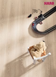 a teddy bear is sitting on a chair in front of a toy track and tracks