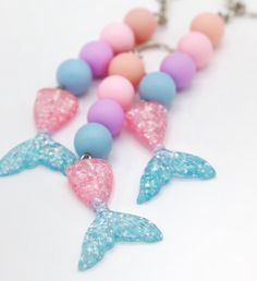 "This beautiful beaded mermaid tail keychain is designed to inspire and add a little whimsy to any bag, backpack, lanyard or set of keys. It's petite charm make it a lovely versatile accessory, a great gift, and something enjoyed by kids and adults as well.  The high quality plated beads and durable waxed cord make a quality stunning product, lovingly handmade by me, with beautiful soft colors and a sparkly, detailed resin mermaid tail charm. Applications include: a gift to treat yourself, party Mermaid Tail Keychain, Mermaid Keychain, Resin Mermaid, Tail Keychain, Classmates Gifts, Beaded Mermaid, Bead Keychain, Cotton Candy Colors, Back To School Gift