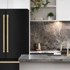 a black refrigerator freezer sitting next to a white counter top with plants on it