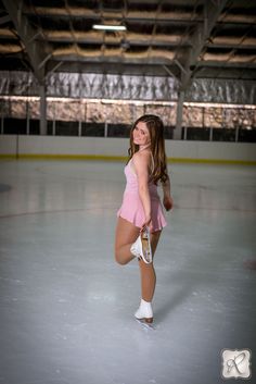 a young woman is skating on an ice rink in a pink dress and white shoes