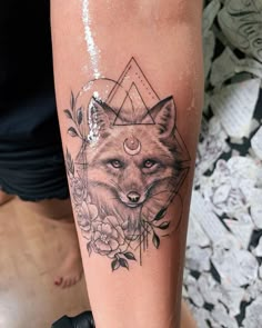 a woman's arm with a tattoo on it that has a fox and flowers