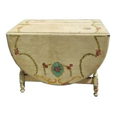 an old wooden box with flowers painted on it's sides and legs, sitting in front of a white background