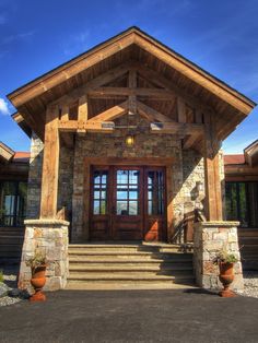 the front entrance to a home with stone and wood