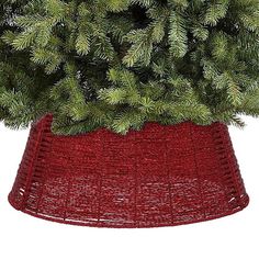 a red vase filled with pine branches on top of a white background, in the shape of a basket