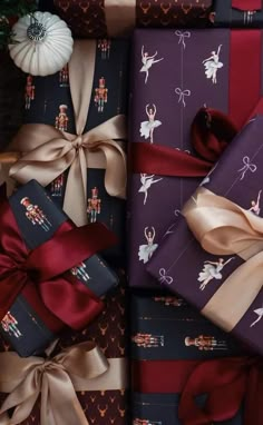 many wrapped presents are stacked on top of each other with ribbons and bows around them