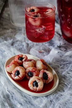 there is a plate full of shrimp on the table next to a glass of red wine