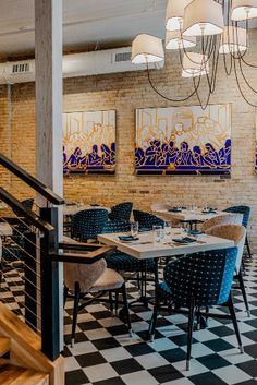 an empty restaurant with checkered flooring and chandeliers hanging from the ceiling