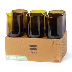 four black glass cups sitting on top of a cardboard box