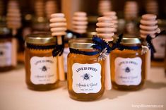 honey jars with labels are lined up on the table for guests to sit in and drink