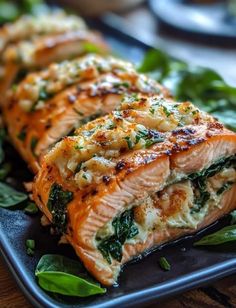 salmon with spinach and cheese on a black plate