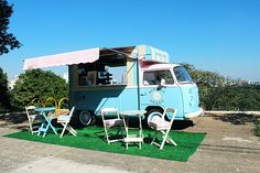 an ice cream truck parked on top of a grass covered field