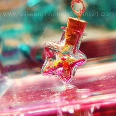 a glass bottle with a cork in it sitting on top of a pink countertop