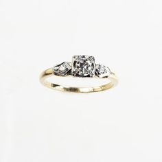 a three stone diamond ring on a white background