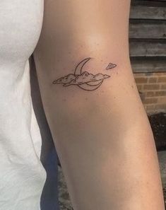 a woman's arm with a small bird tattoo on the left side of her arm