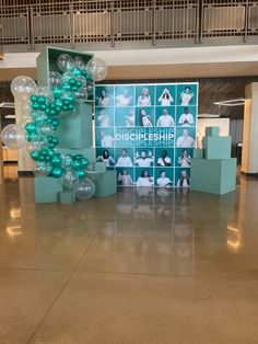 balloons are arranged in the middle of an open floored area with photos on it