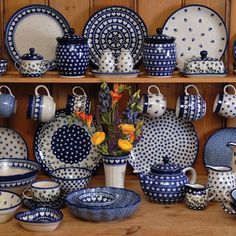 blue and white dishes are on display with flowers