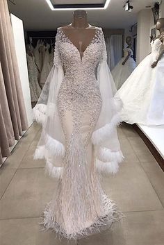 a wedding dress with feathers on the skirt