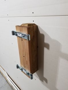 a wooden box mounted to the side of a wall with two metal brackets on it