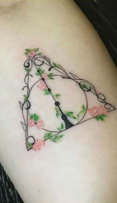 a tattoo design on the side of a woman's arm with flowers and a clock