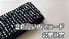 there is a black and white knitted object on the table with japanese words below it