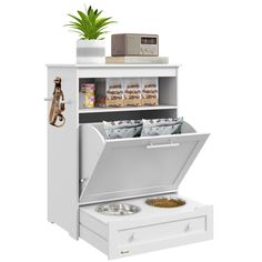 a white cabinet with an open drawer and some food in it on top of a table