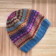 a multicolored knitted hat laying on the floor