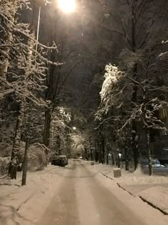 the street is covered in snow at night