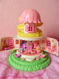 there is a doll house with a princess castle on the top and pink walls behind it