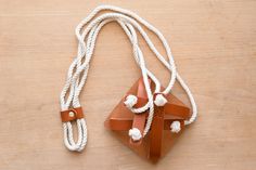 a brown and white necklace on top of a wooden table