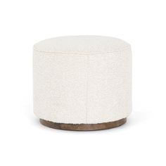 a small white ottoman with wood base