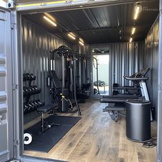 the inside of a large metal container with exercise equipment in it and lots of windows