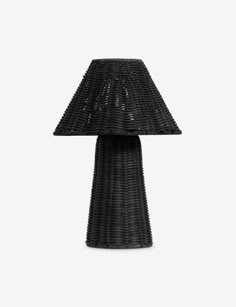 a black table lamp sitting on top of a white wall