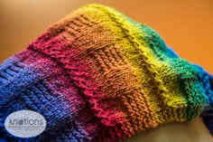 a multicolored knitted hat on top of a mannequin's head