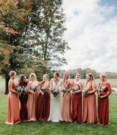 a group of women standing next to each other on top of a lush green field