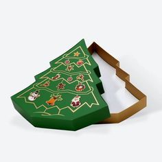 a green christmas tree shaped cookie box with stickers on the top and bottom side