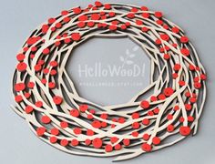 a red and white wreath with wooden branches