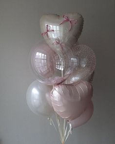 a bunch of balloons that are in the shape of a heart and some pink bows