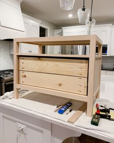 a kitchen island with drawers and tools on it