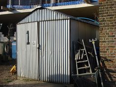 a metal shed sitting next to a brick building