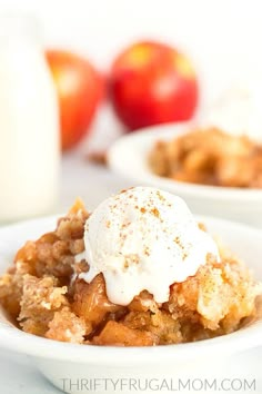 two bowls filled with apple crisp on top of a table next to milk and apples