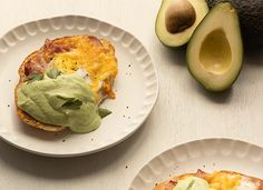 an avocado is on the table next to two plates with food