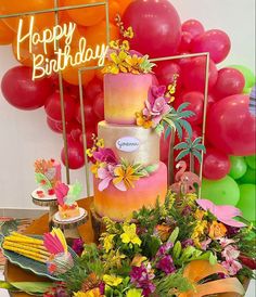 a birthday cake sitting on top of a table next to balloons and other decor items