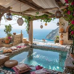 an outdoor swimming pool with lots of plants and flowers on the ground next to it