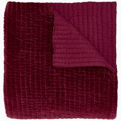 the burgundy blanket is folded up and ready to be used as a bedding material